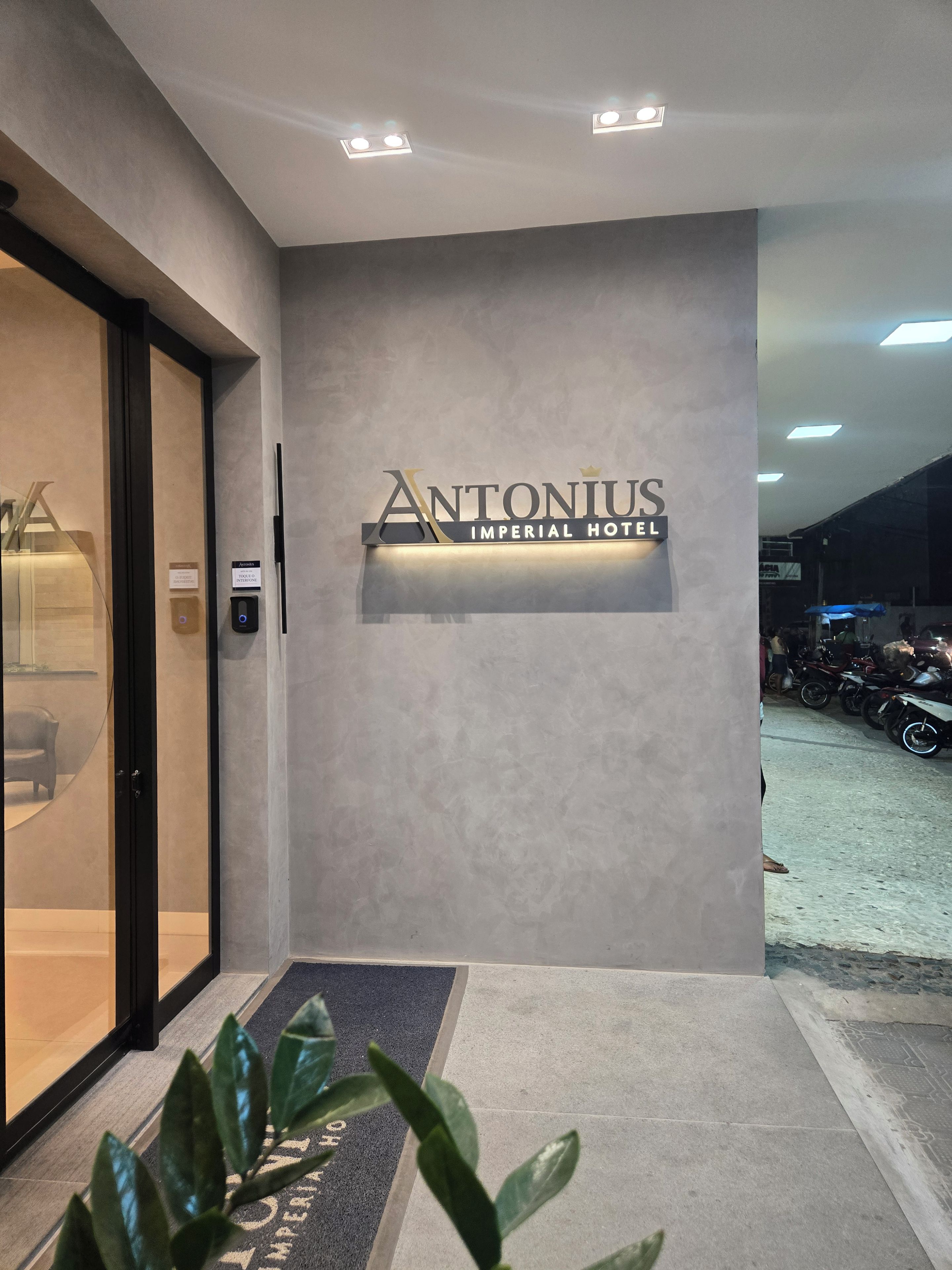 The entrance to the Antoniius Imperial Hotel with a modern design, a reception desk, and a digital information kiosk.