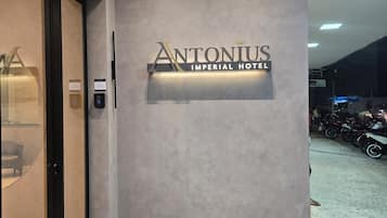 The entrance to the Antoniius Imperial Hotel with a modern design, a reception desk, and a digital information kiosk.