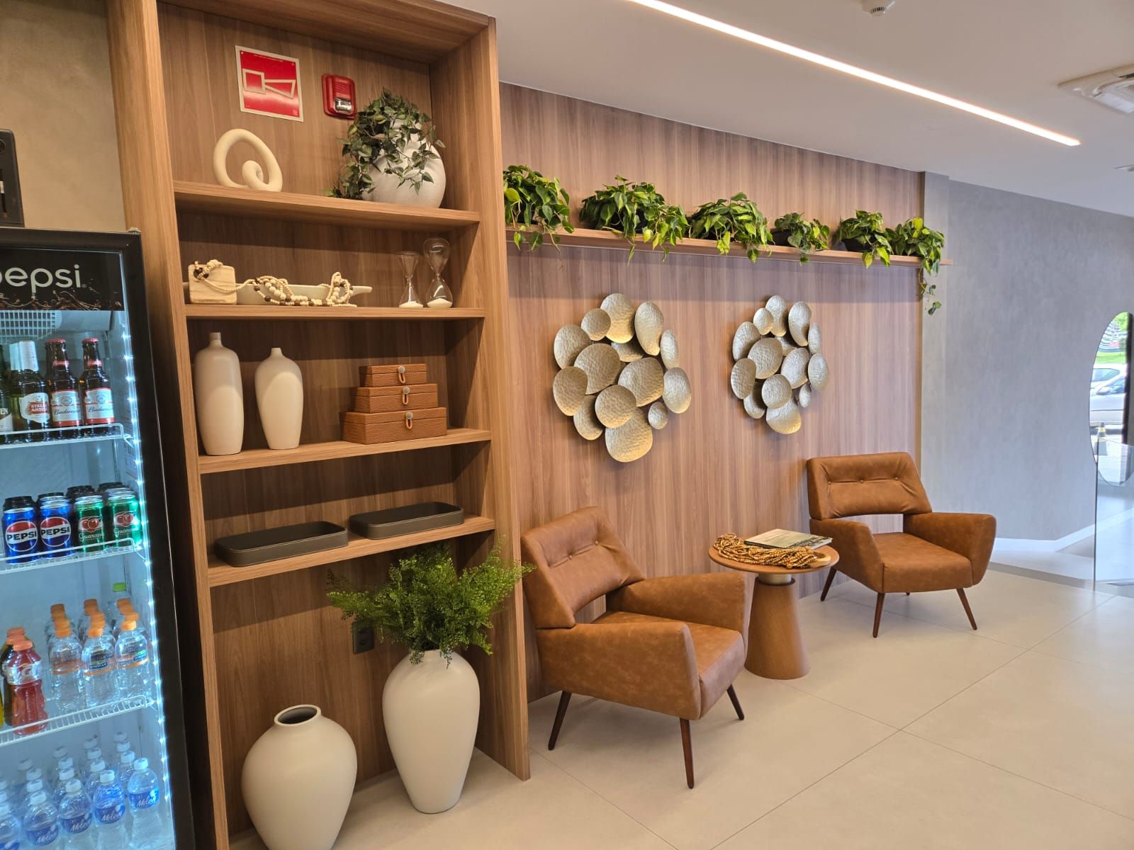 A modern interior with a vending machine, wooden shelves, seating area, and decorative wall art.