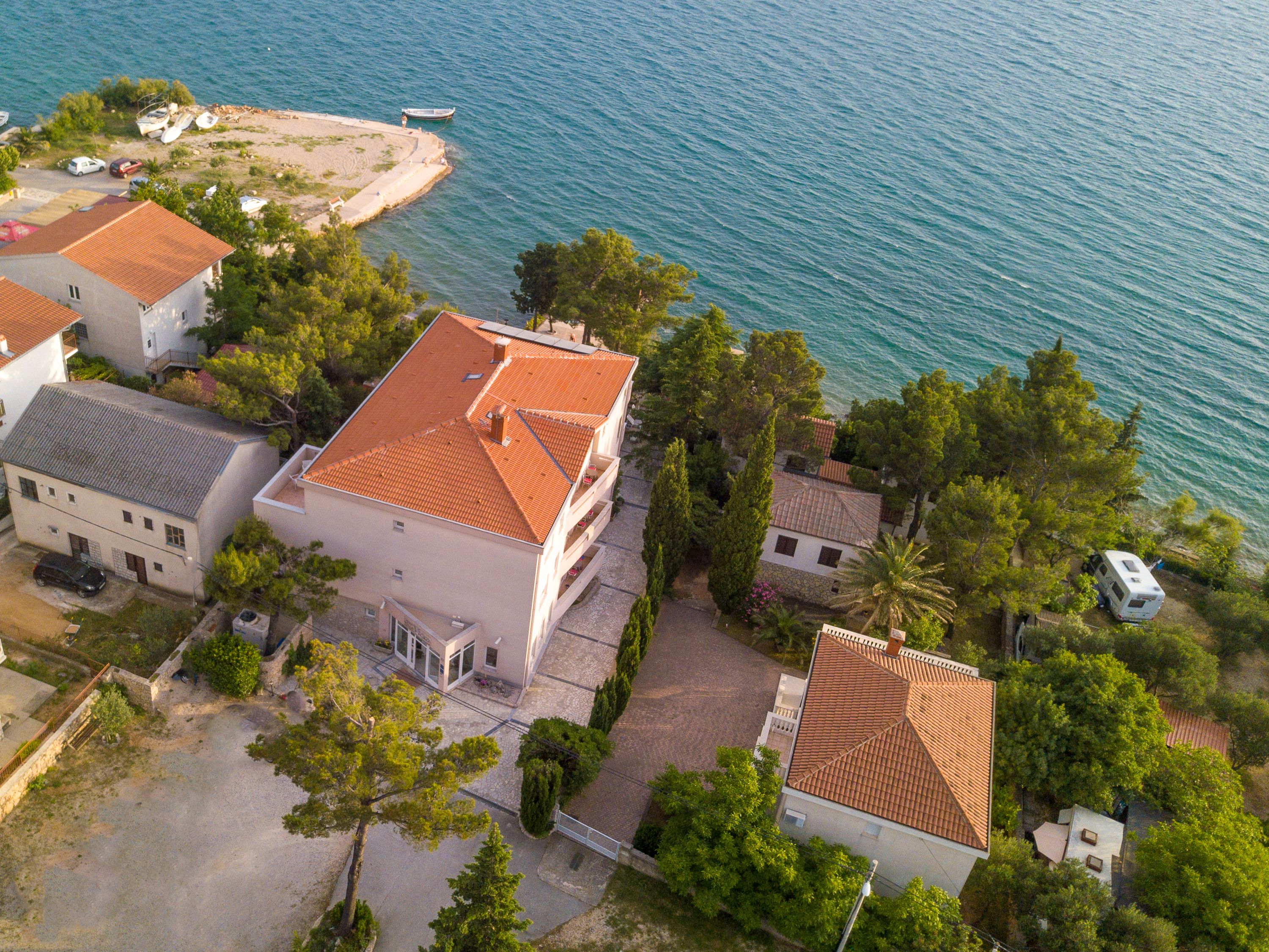 Vista aérea de una zona residencial costera con casas, una playa y barcos.
