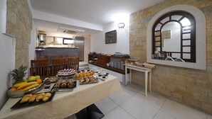 A dining area with a buffet table, stone walls, and a view of the kitchen. - Villa Vicko (Starigrad)