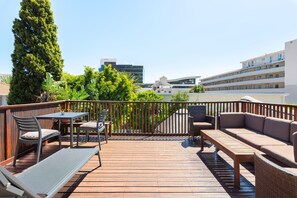 Relax and socialize in our spacious outdoor deck area, featuring a variety of seating options and a safe, bordered space with a view of the surrounding urban landscape.