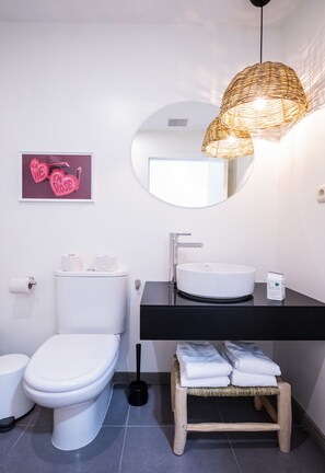 Een bad/douchecombinatie, een haardroger, handdoeken