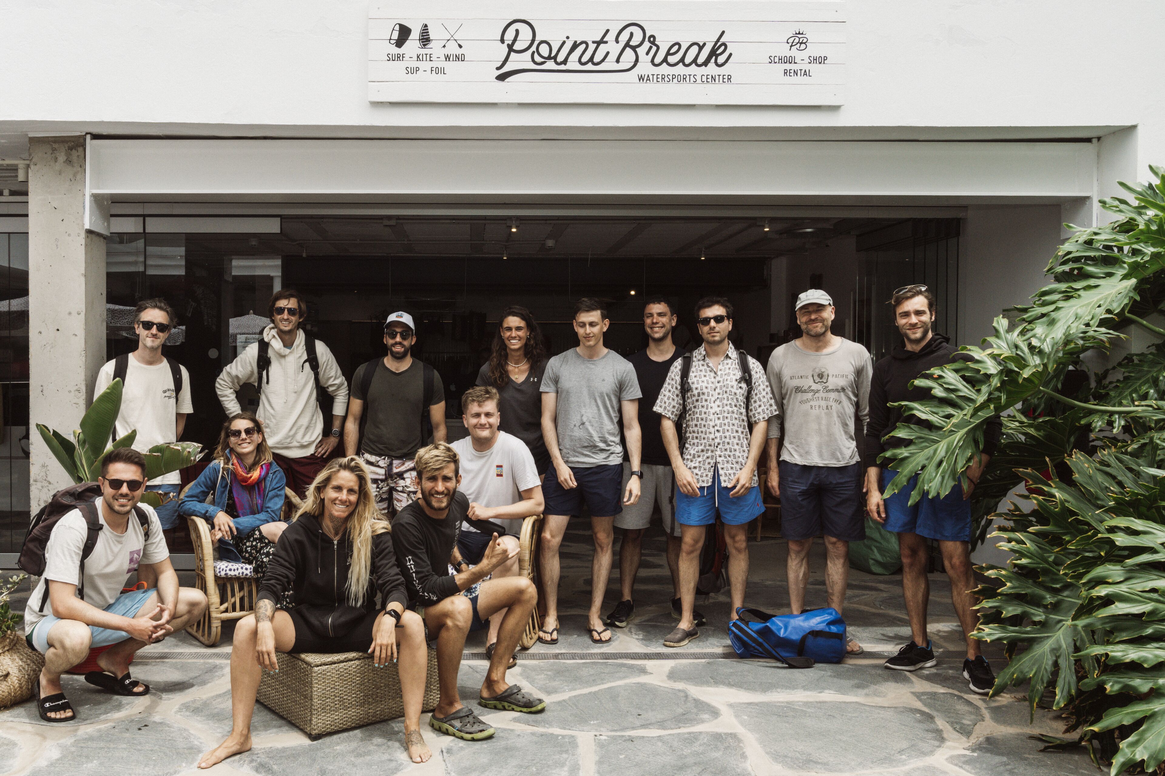 A group of people standing in front of a building with a sign that reads "Point Break Watersports Center".