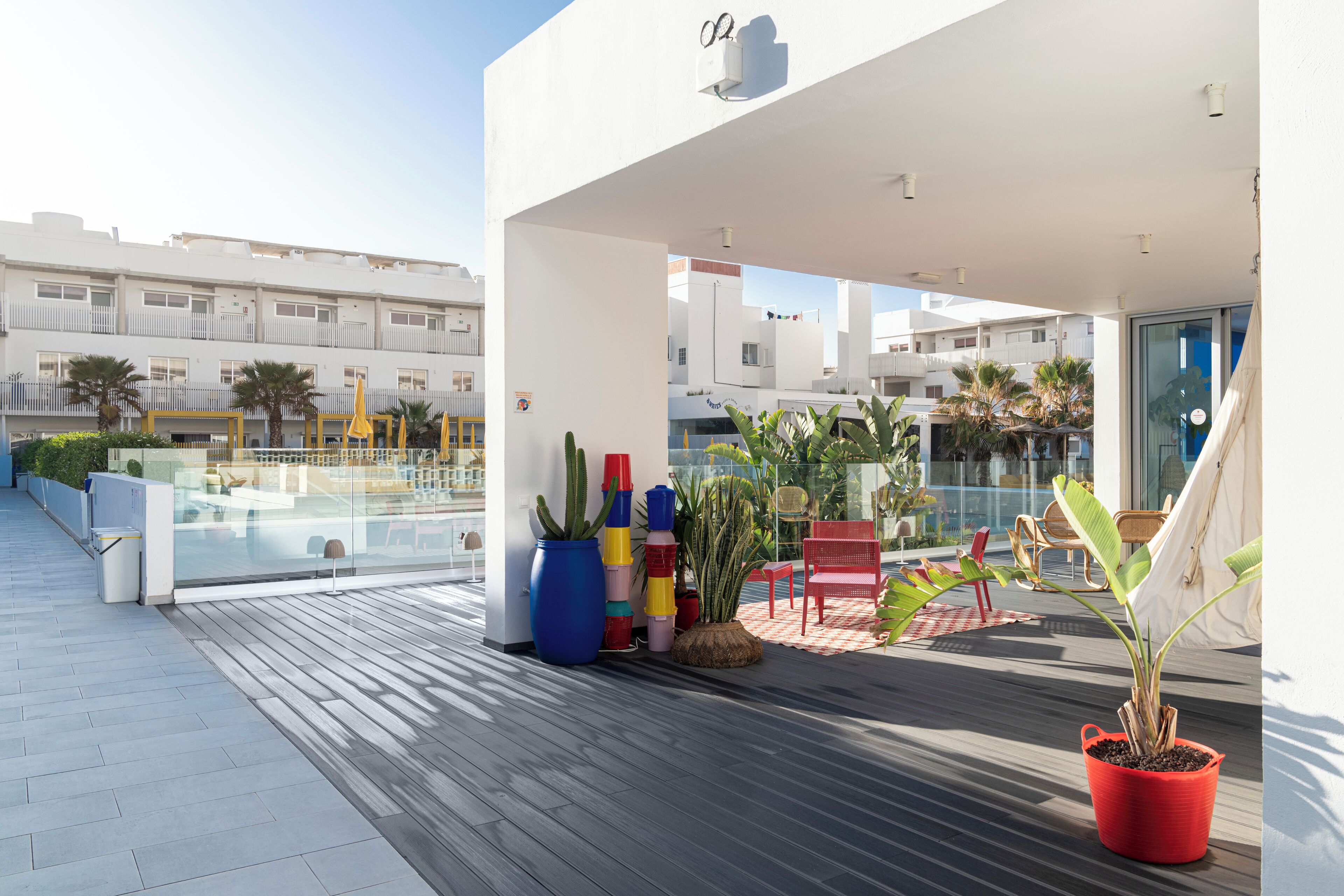A modern outdoor terrace with a pool, potted plants, and seating areas.
