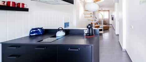 A modern kitchen with a central island, a built-in oven, and a microwave.