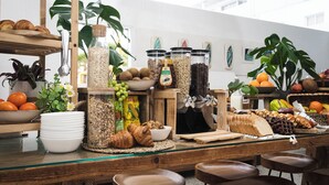 Un buffet de petit-déjeuner proposant une variété d'aliments, notamment des fruits, des viennoiseries et des condiments.