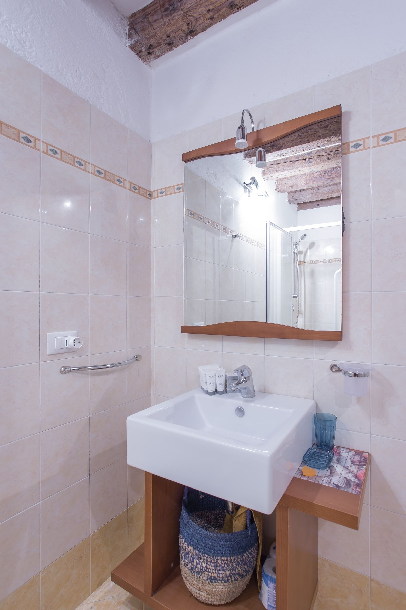 A bathroom with a white sink, a mirror, and a shower.