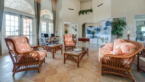 A spacious lobby with wicker furniture, large windows, and a reception area.