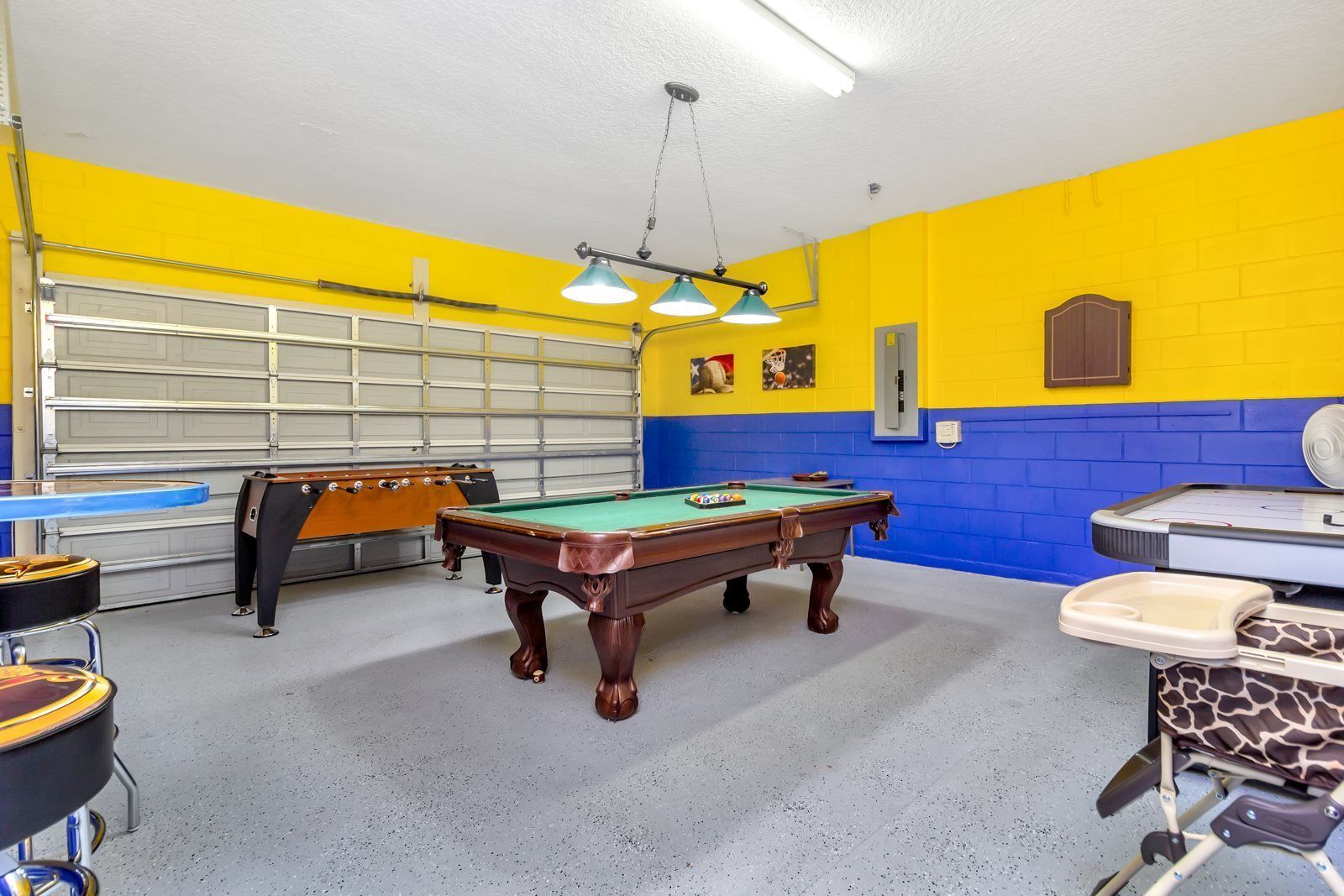 Una sala de billar con mesa de billar, mesa de fútbol de mesa y mesa de tenis de mesa.