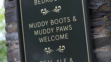 A sign advertising 10 en suite bedrooms, muddy boots & muddy paws welcome, real ale & craft beers, and food served daily.