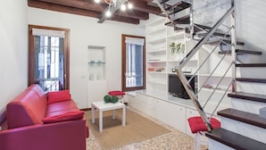 Ein modernes Wohnzimmer mit einem roten Ledersofa, einem weißen Couchtisch und einer Treppe mit Metallgeländer.
