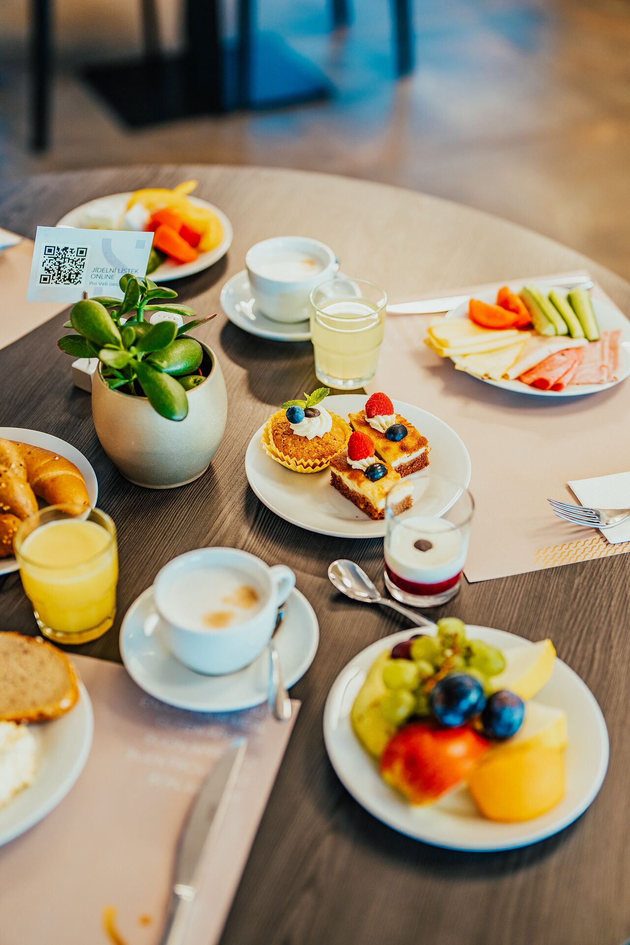 A table with various breakfast items including pastries, fruit, and beverages.