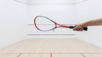A squash court with a red and black racket.