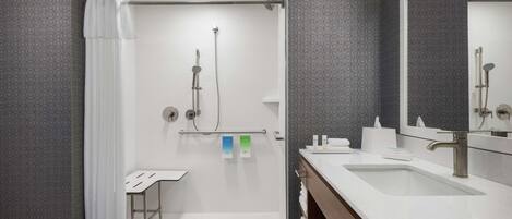 Ein modernes Badezimmer mit Dusche, Waschbecken und Spiegel.