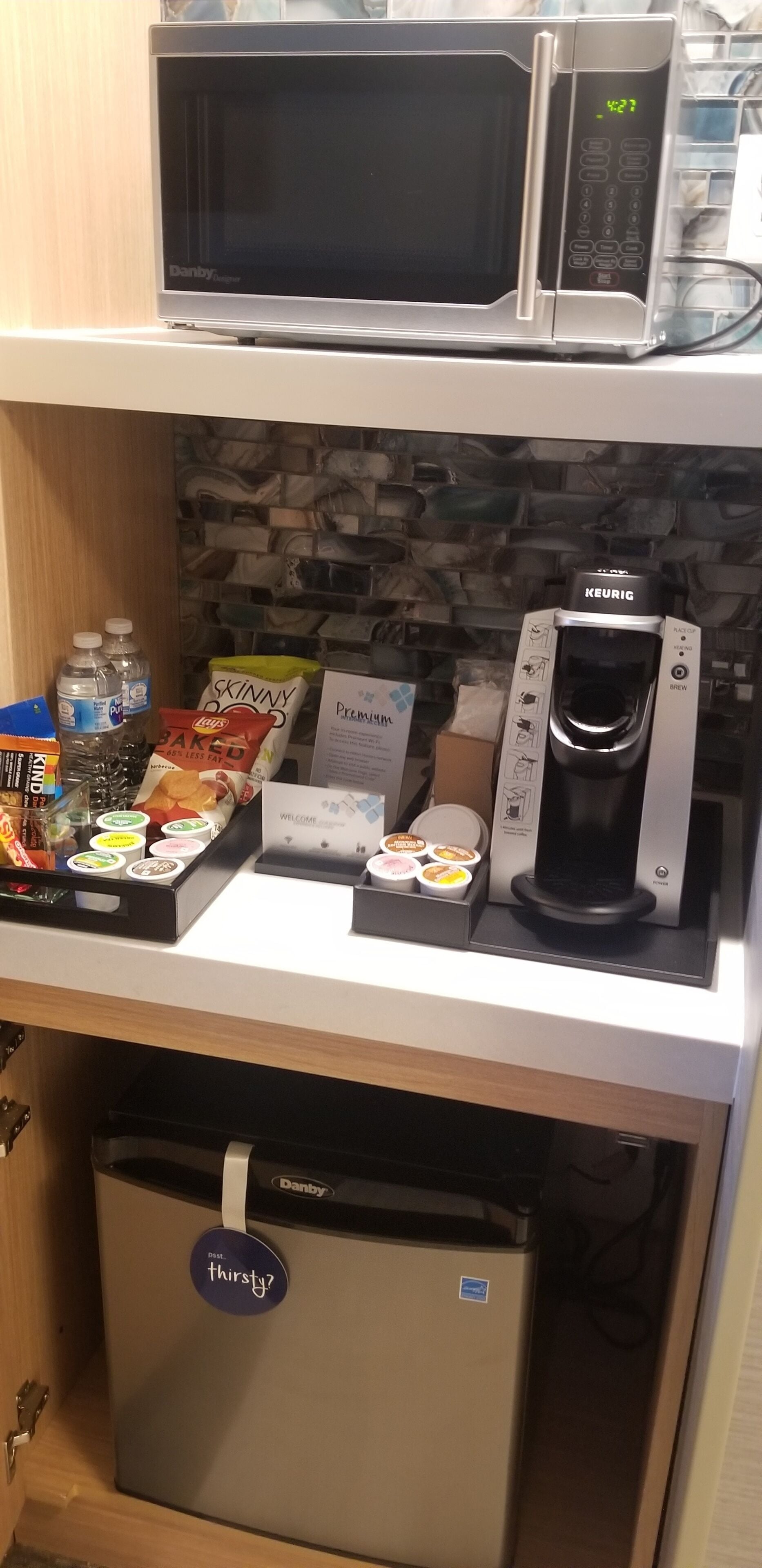 Une petite cuisine équipée d’un four à micro-ondes, d’une machine à café et d’un réfrigérateur.