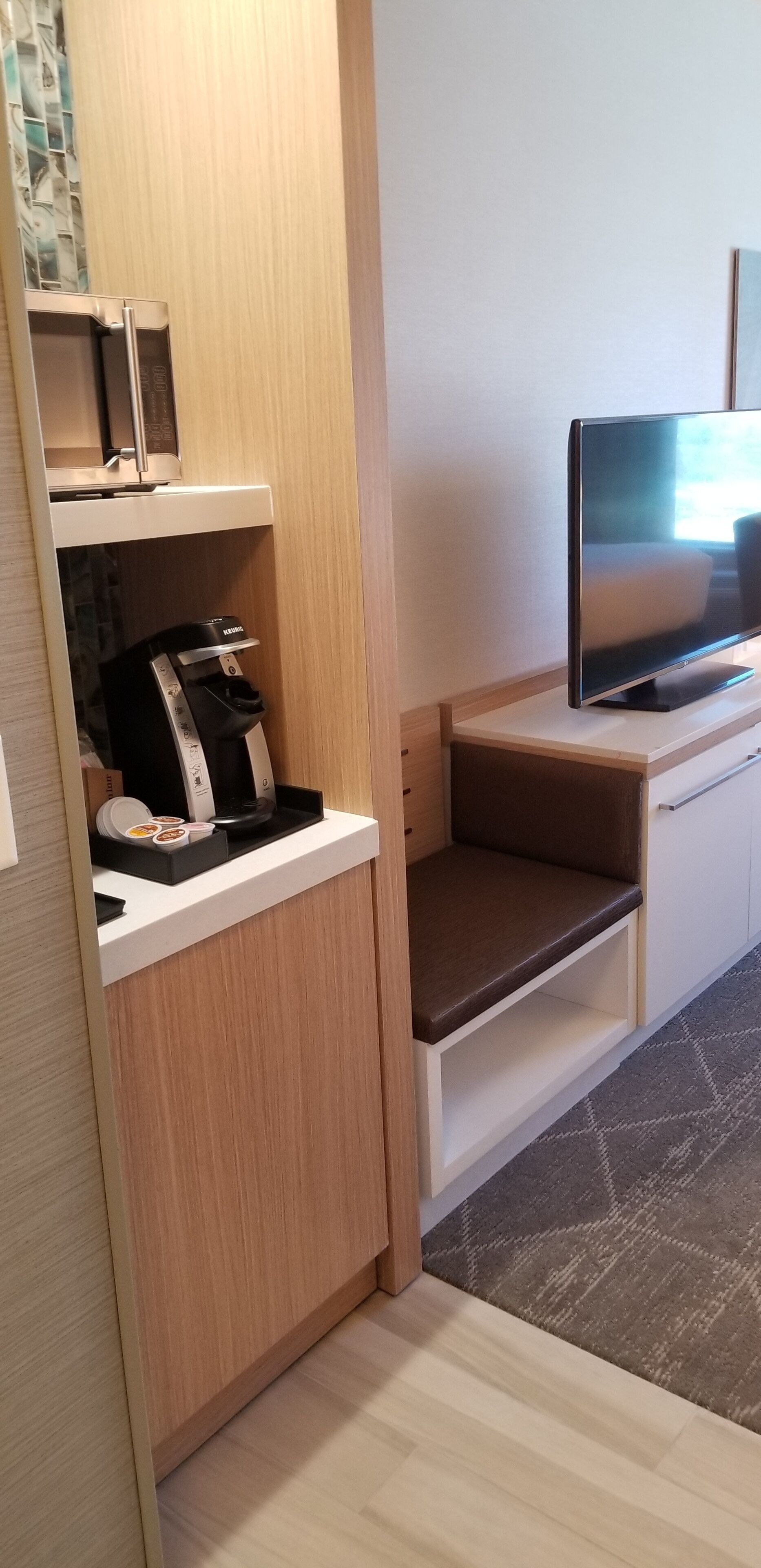 Un espacio habitable compacto con kitchenette, televisor de pantalla plana y zona de estar.