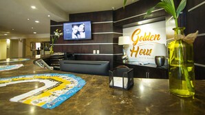 Un espace d’accueil comprenant un comptoir de réception, un téléviseur fixé au mur et une enseigne indiquant « Golden House Hotel & Restaurant ».