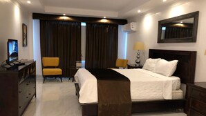 Une chambre d’hôtel équipée d’un lit, d’un bureau, d’une chaise et d’un téléviseur.