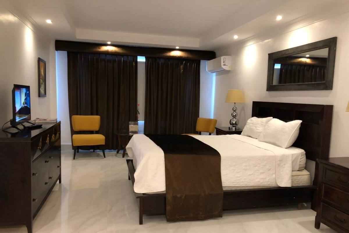 Ein Hotelzimmer mit Bett, Schreibtisch, Stuhl und Fernseher.