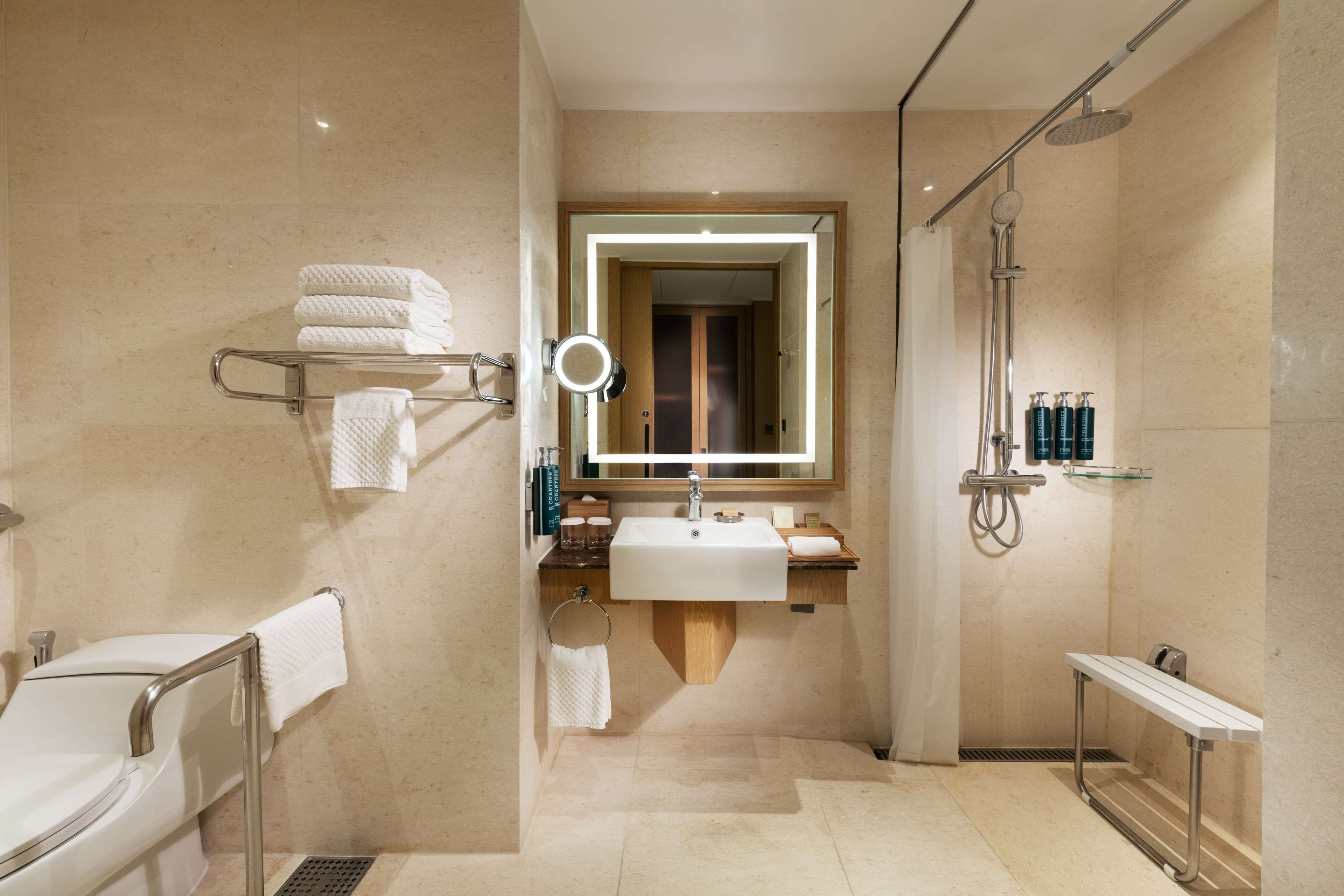 A modern bathroom with a glass-enclosed shower, a vanity with a mirror, and a towel rack.