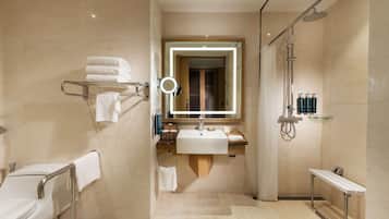 A modern bathroom with a glass-enclosed shower, a vanity with a mirror, and a towel rack.