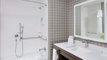 A bathroom with a bathtub, a shower, a sink, and a mirror.