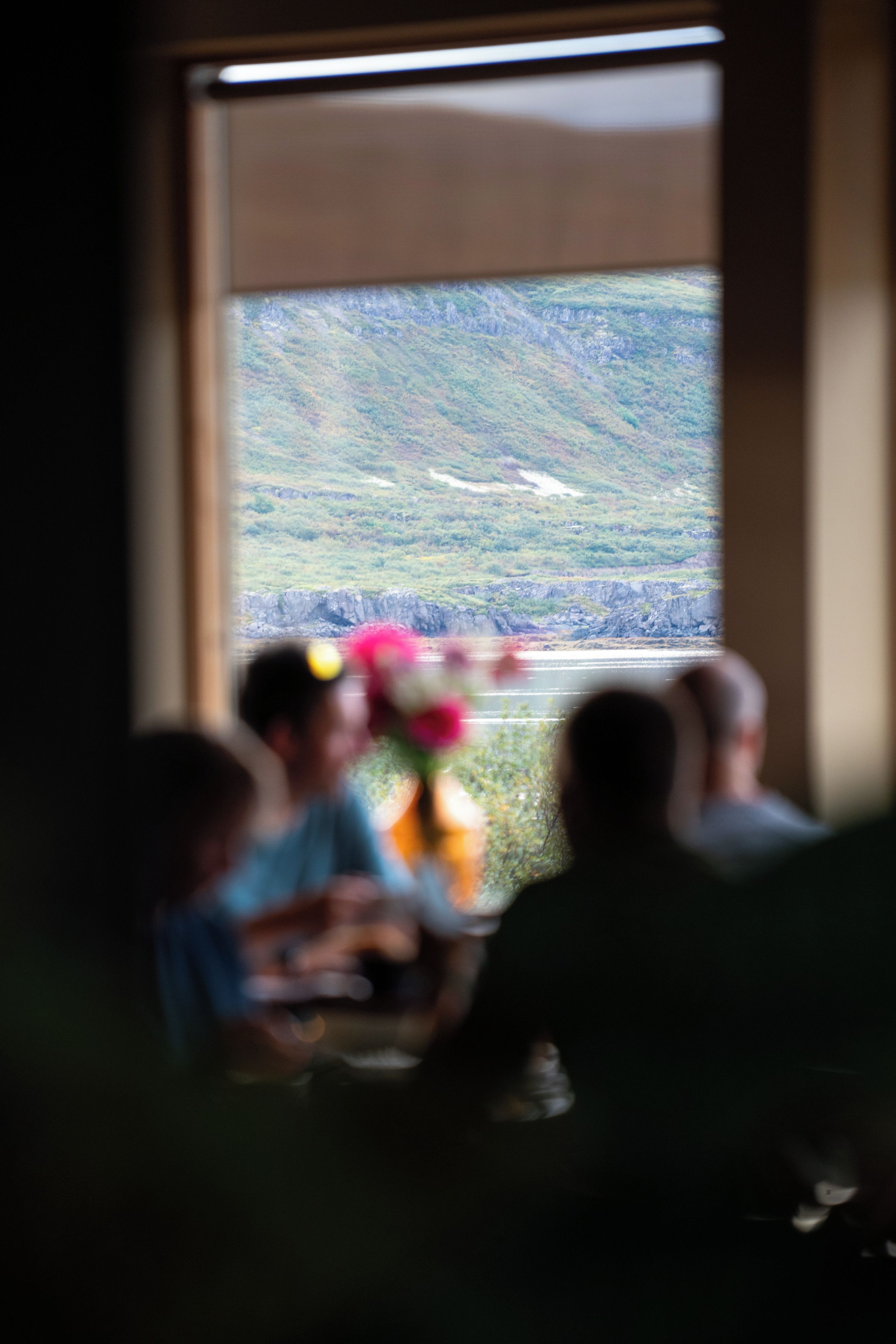 A room with a window overlooking a mountainous landscape.