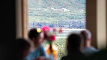 A room with a window overlooking a mountainous landscape.