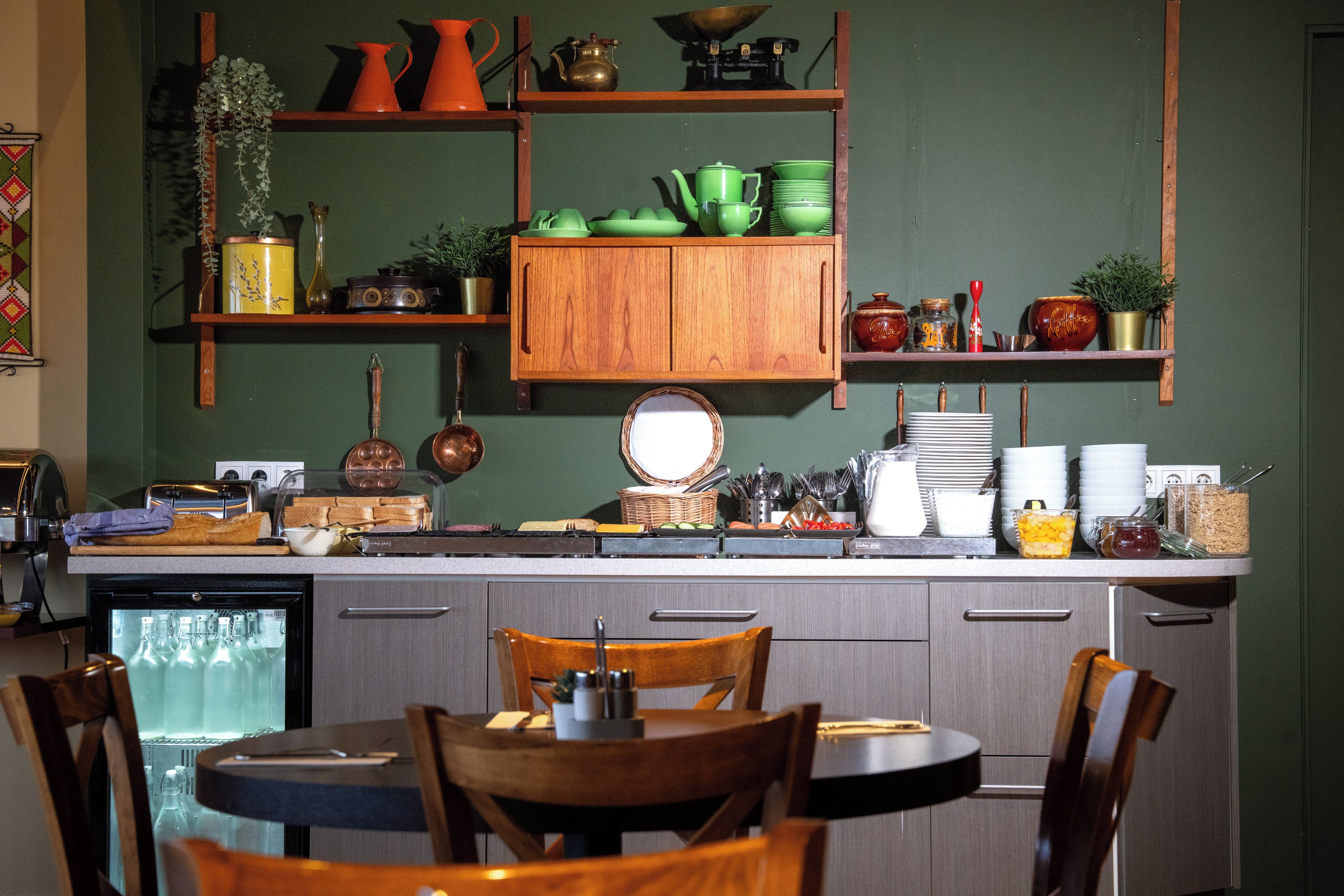 Una cocina con armarios de madera, una mesa de comedor, sillas y varios utensilios y electrodomésticos.