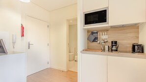 Una cucina moderna con mobili bianchi, un forno a microonde e una macchina per il caffè.