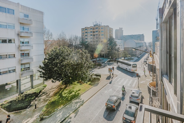 A city street with buildings, a bus, and cars.