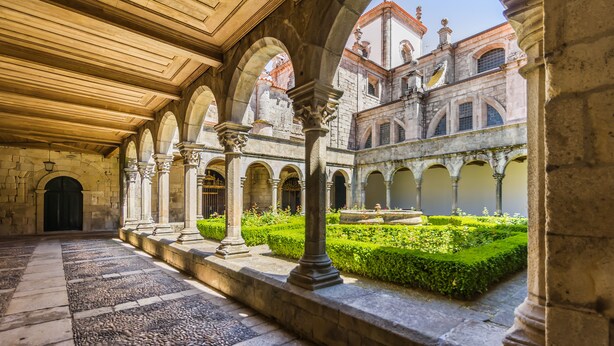 A courtyard with stone columns, a fountain, and a garden. - Casa de Monsanto I Lamego (Lamego)