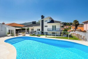A swimming pool with a house in the background.