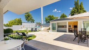 A modern house with a patio, outdoor seating, and a kitchen visible through glass doors. - Casa de Monsanto I Lamego (Lamego)