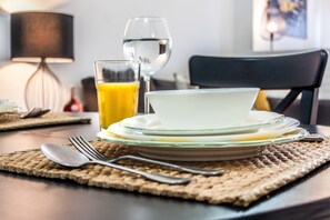 A dining table with a plate, glass, and juice, set on a woven placemat. - Paraíso Alfama (Lisbon)