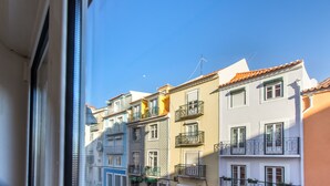 A row of colorful buildings with balconies and a clear blue sky. - Paraíso Alfama (Lisbon)
