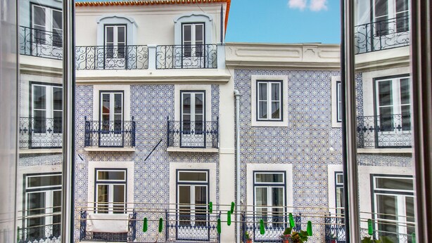 A building with multiple balconies and windows, featuring a patterned facade. - São Vicente Heart of Alfama (Lisbon)
