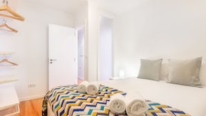 Una habitación de hotel con cama, armario y puerta que da a otra estancia.