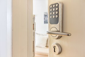 A modern door with a numeric keypad lock and a keyhole.