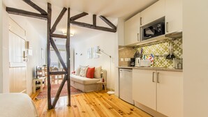 Una cucina moderna con pavimento in legno, un'area pranzo con divano e un bancone della cucina in vista.