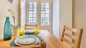 Un tavolo da pranzo con piatti, un bicchiere di succo d'arancia e un vaso con fiori.