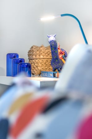 A desk with a blue lamp, a blue figurine, a pineapple-shaped object, and a small blue sign. - Luxury Beach Experience in Lisbon (Oeiras)