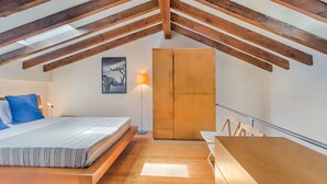 A bedroom with a loft bed, a wooden desk, and a wardrobe. - Graça Cozy Duplex (Lisbon)