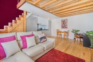 Una sala moderna con una escalera, un comedor y una cocina.
