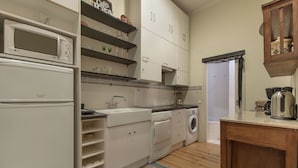 A compact kitchen with white cabinetry, a microwave, a dishwasher, and a coffee maker. - Correeiros Downtown - Historic Lisbon Apartment (Lisbon)