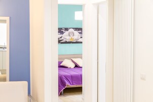 Un dormitorio con una cama, almohadas y un cuadro de una orquídea colgado en la pared.