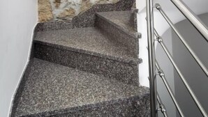 Una escalera con paredes de piedra y barandales de metal.