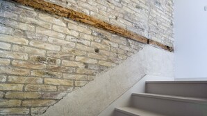 A staircase with a brick wall on one side and a plain wall on the other. - Nera Luxury Apartments (Split)