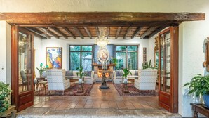 A cozy living room with a fireplace, comfortable seating, and a view of the outdoors.